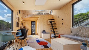 Un interior moderno con paredes de madera, un ventanal grande, una zona de comedor y un espacio de descanso.