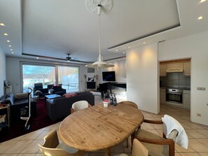 Una cucina moderna con forno integrato e zona pranzo con tavolo e sedie in legno.