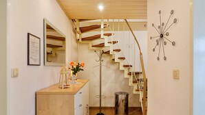 Eine Treppe mit Holzbodenstufen und einer spiralförmigen Metallverzierung an der Wand.
