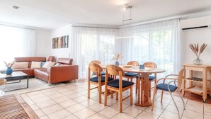 A modern living room with a sofa, dining table, chairs, and a coffee table. - Holiday Apartment 'Iris und Uwe' with Mountain View, Private Terrace and Wi-Fi (Markdorf)