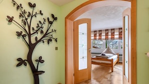 Un dormitorio con una cama, una puerta de madera y vistas a través de una ventana.