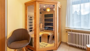 Una habitación con un armario de madera, una silla y una ventana con cortinas.