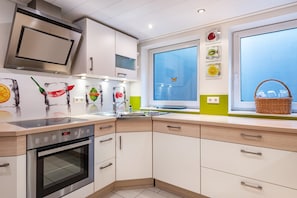 A modern kitchen with a built-in oven, a microwave, and a large window with a view.