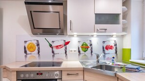 Una cocina moderna con horno empotrado, estufa, fregadero y microondas.