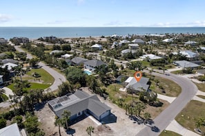 A residential area with houses, a swimming pool, and a view of the ocean.