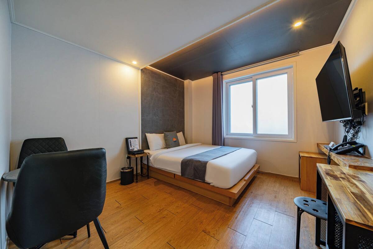 A modern bedroom with a bed, a desk, and a chair.