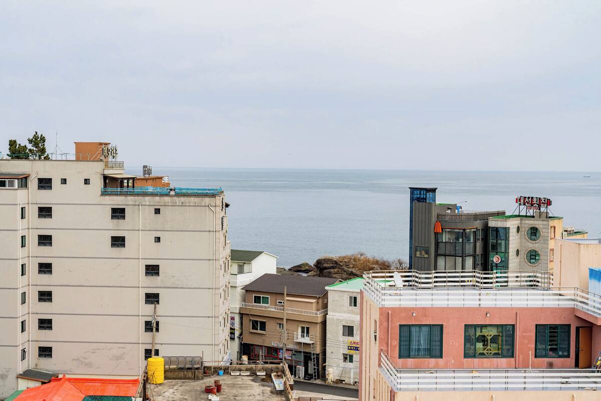 A coastal building complex with multiple floors, balconies, and a view of the sea.