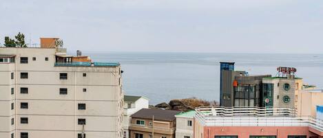 Un ensemble de bâtiments situé sur la côte, comprenant plusieurs étages, des balcons et offrant une vue sur la mer.