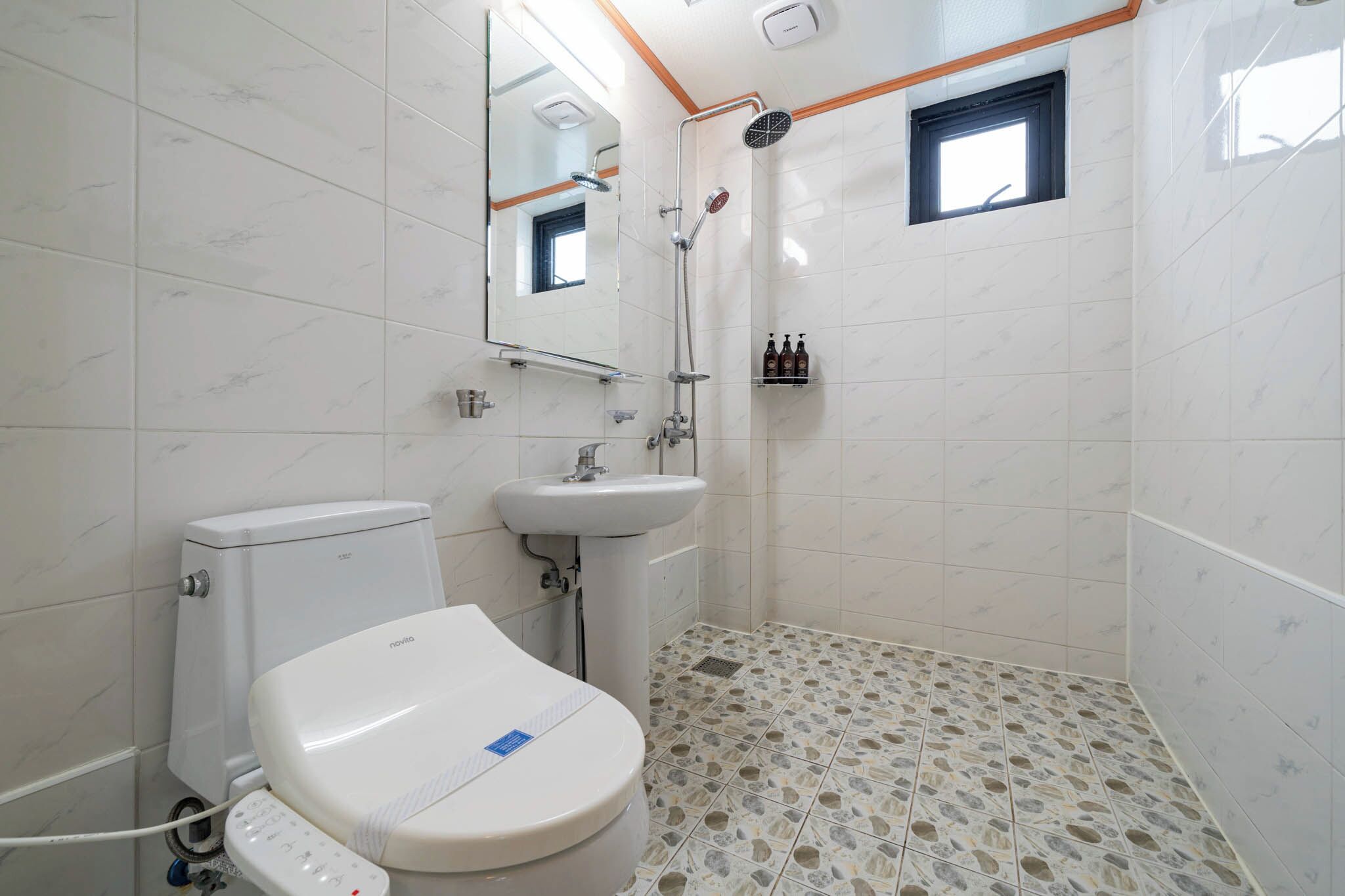 Un baño con inodoro, lavabo y ducha.