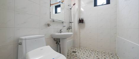 Un baño con inodoro, lavabo y ducha.
