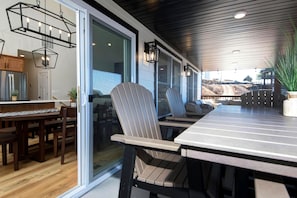 A modern kitchen with a built-in refrigerator, wooden cabinets, and a dining area with a long table and chairs.
