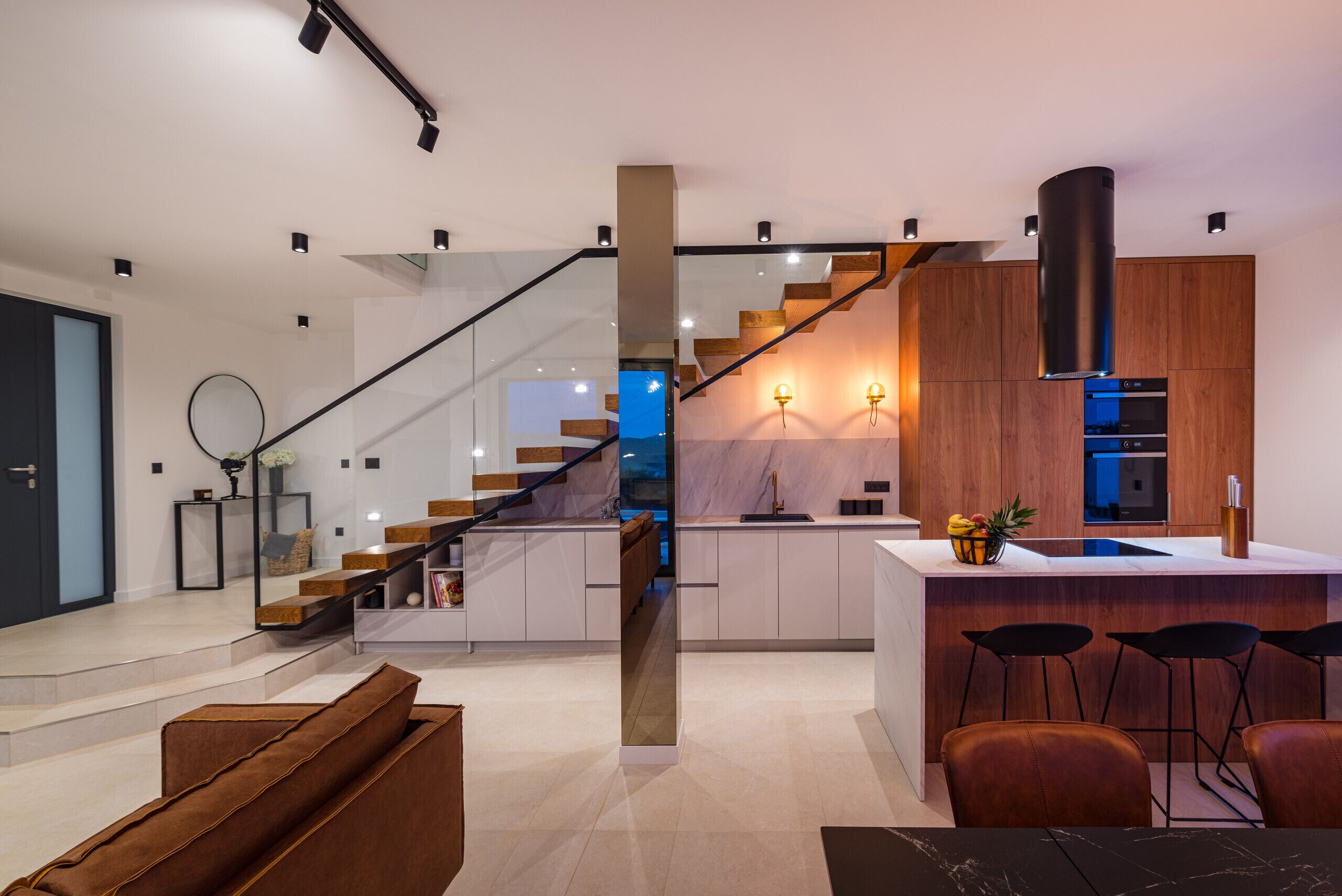 Een moderne keuken met een centraal eiland, houten kastjes en een roestvrijstalen afzuigkap.