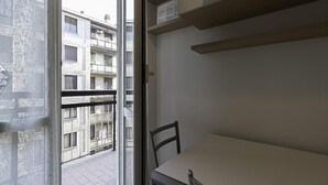 A room with a balcony, a table, and a chair. - Italianway - Martinetti 21 B (Milan)