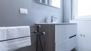 A modern bathroom with a towel rack, a sink, and a mirror. - Italianway Comfort - Merlo 1 F (Milan)