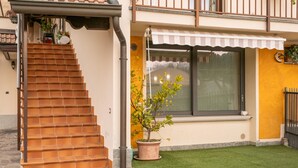 A staircase leading to a house with a small garden and a window with a striped awning. - Franciacorta Family Friendly (Adro)
