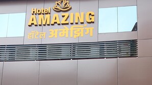 A building with a sign reading "Hotel Amazing" and a lotus symbol above the text.