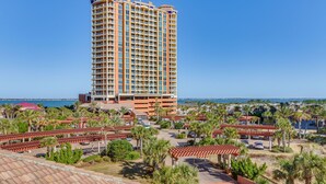 Un hôtel de grande hauteur doté de nombreux balcons, d’un parking et offrant une vue sur la mer.