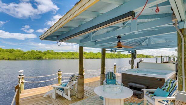 Una terraza con jacuzzi, sillas de descanso y una mesa.