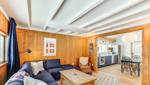 Una sala de estar acogedora con un sofá, una mesa de centro y un comedor con sillas y una mesa.