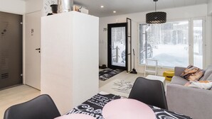 A modern living room with a grey sofa, black chairs, and a coffee table with a black and white patterned table runner. - Hillaniitty by Interhome (Kuusamo)