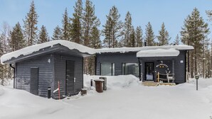 A cabin with a dark exterior, a covered porch, and a sign reading "WILDLANDY". - Hillaniitty by Interhome (Kuusamo)