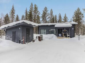 A cabin with a snow-covered roof, a small attached structure, and a clear sky. - Hillaniitty by Interhome (Kuusamo)