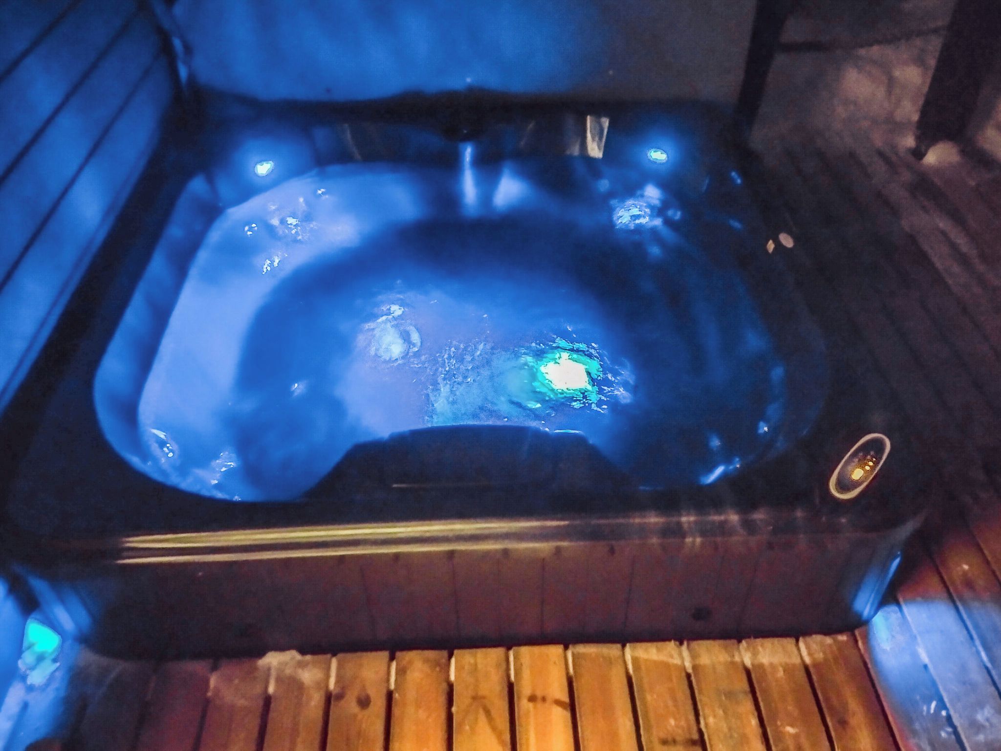 Un bain à remous entouré d’un plancher en bois.