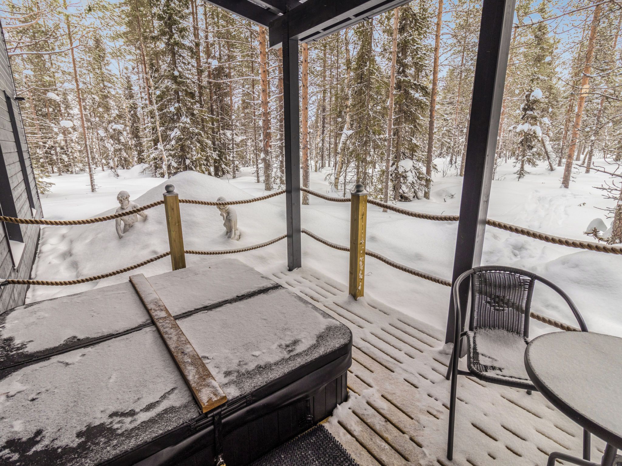 Un espacio exterior con nieve y vistas a un bosque.
