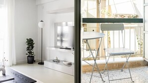 Et moderne, veloplyst rum med et stort vindue, et spiseområde med en metalstol og en potteplante.
