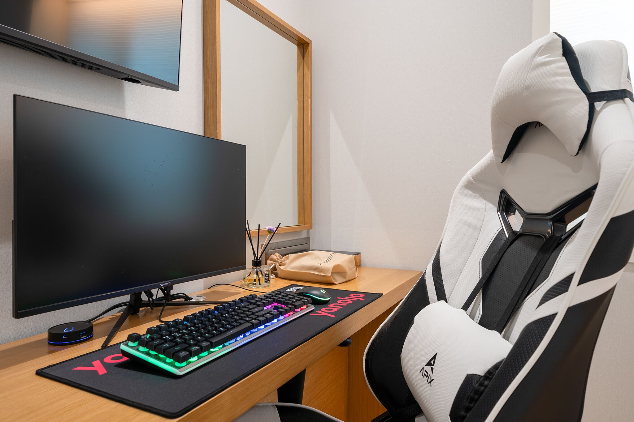 Um espaço gamer com monitor, teclado, rato e cadeira ergonômica.