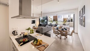 A modern kitchen with an island, dining area, and living space. - Protaras By the Bay Villa 32 (Paralimni)