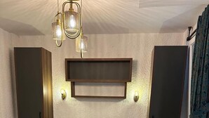 A hotel room with a bed, a nightstand, a wall-mounted TV, and a patterned floor. - Lotus City Siğacık Boutique Otel (Seferihisar)