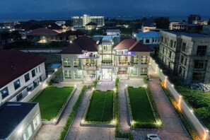 A large, multi-story building with a central courtyard, surrounded by smaller buildings. - The city Block Apartment (Bujumbura)