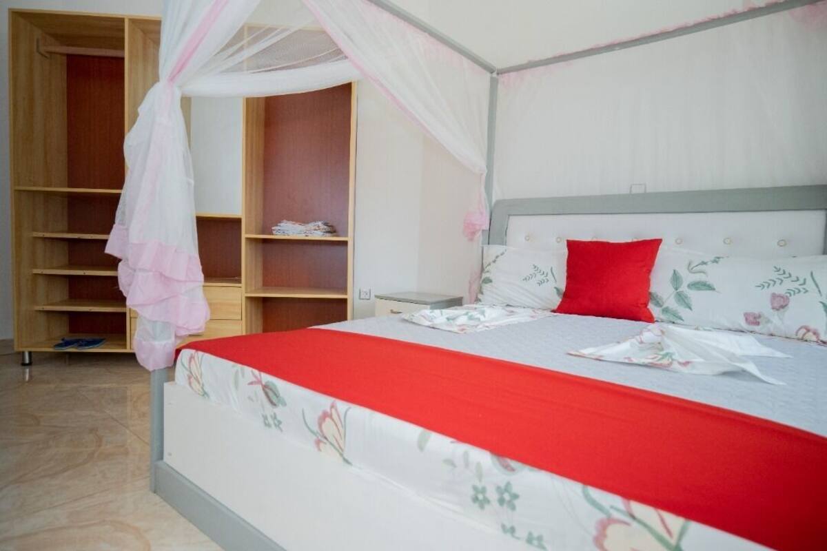 Une chambre à coucher avec un lit à baldaquin, une armoire et une table de chevet.