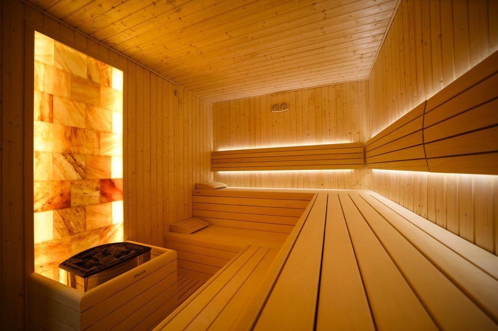 A wooden sauna with benches and a heated wall.