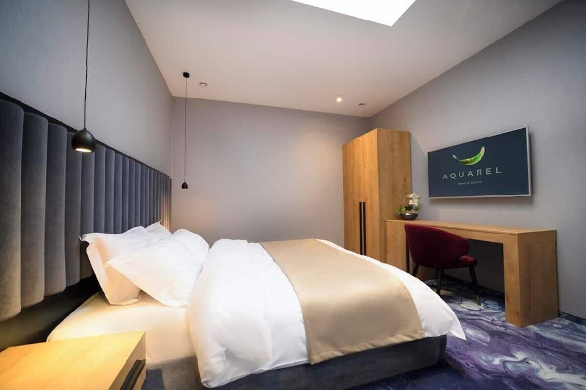 Una habitación de hotel moderna con una cama, un escritorio y una silla.
