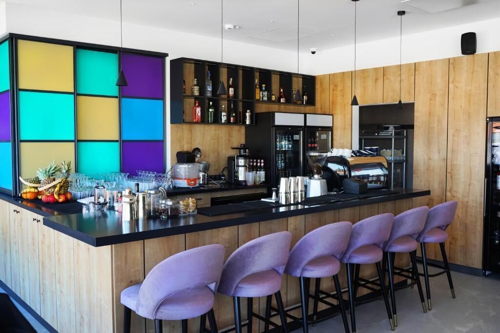Eine moderne Küche mit Barbereich, Holzschränken und Barhocker.