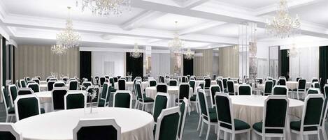 A banquet hall with round tables, green chairs, white tablecloths, and chandeliers.