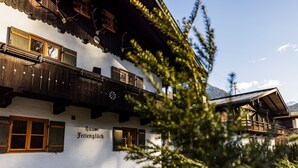 Een chalet in traditionele stijl met houten balkons en een bordje met de tekst 'Haus Ferienlück'.