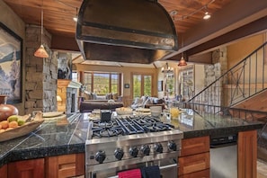 A spacious kitchen with a large island, a built-in stove, and a stone accent wall. - Abode at The Outlaw, private hot tub, mountain retreat (Park City)