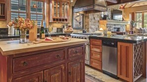 Una cocina amplia con armarios de madera, una isla grande e iluminación colgante.
