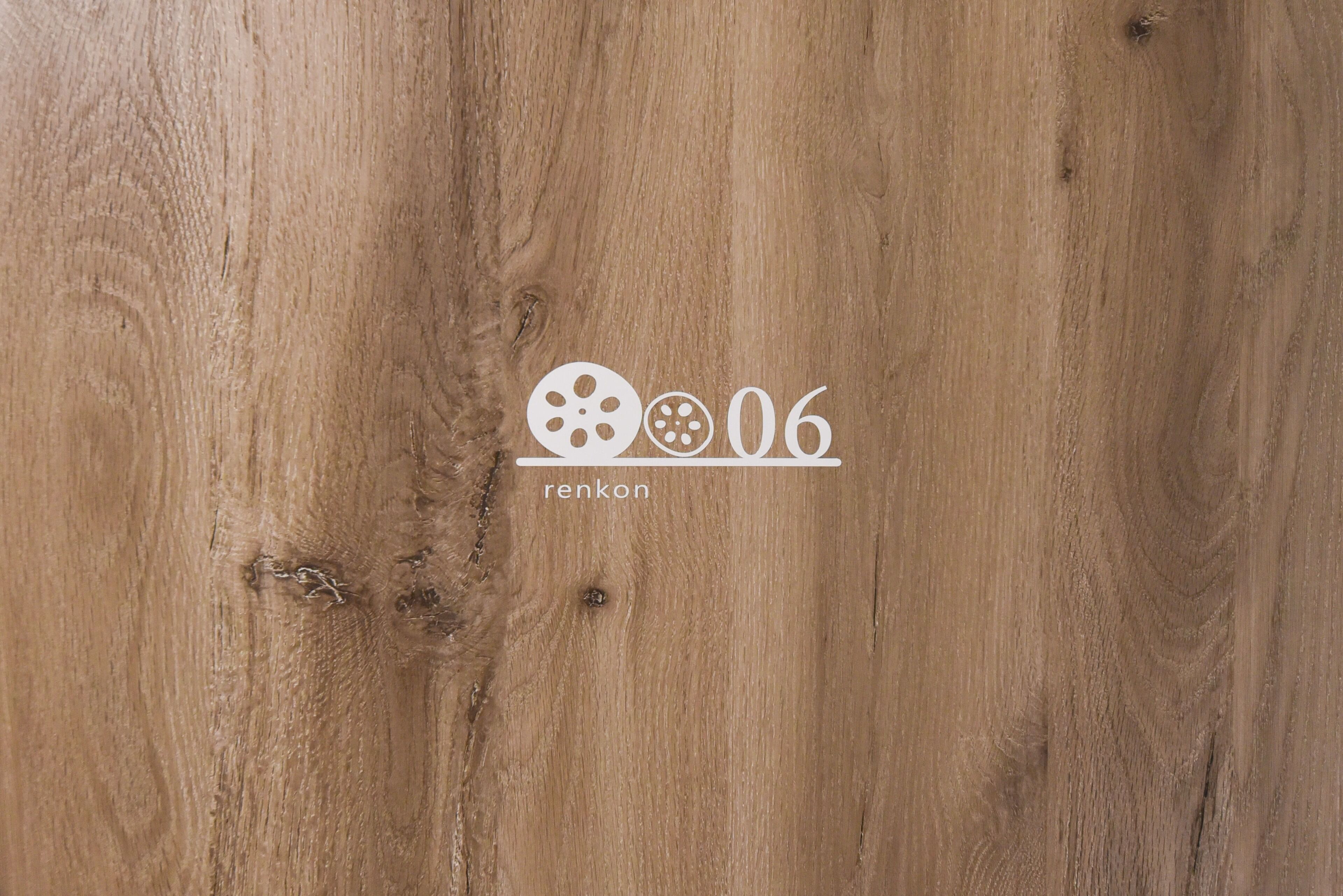 A wooden surface with a logo and text reading "renkon 06".