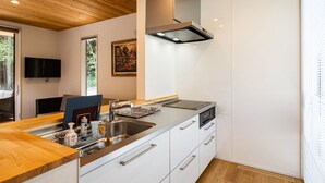 Una cocina moderna con encimera de madera, electrodomésticos de acero inoxidable y horno integrado.