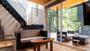 Una sala de estar moderna con un sofá, una mesa de centro y una escalera.