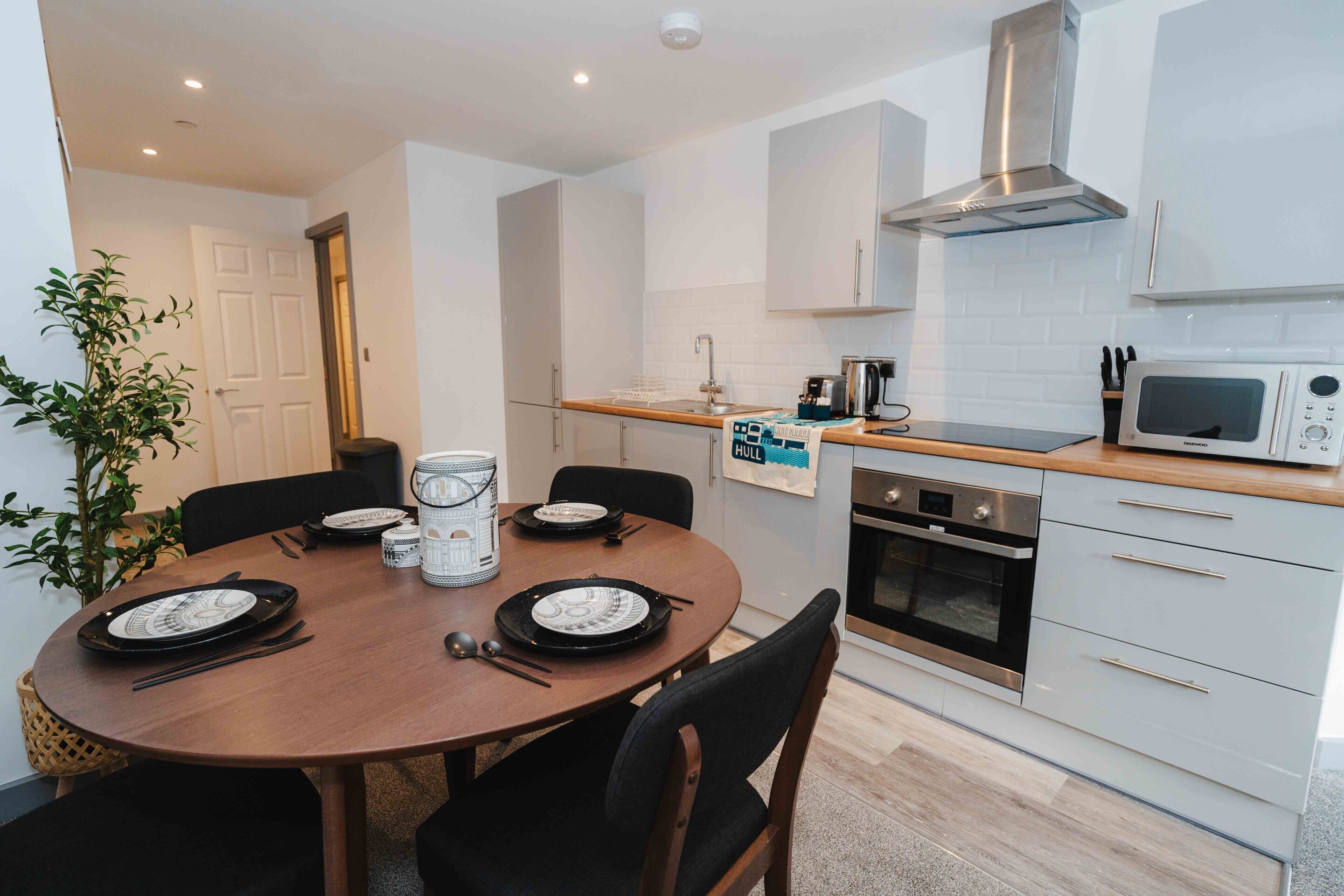 A compact kitchen with a microwave, oven, and stainless steel range hood.
