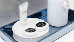 A tray with a white container labeled 'Just for you,' a tube, and two round containers with black lids. - Street View Modern Apartment (Hull)