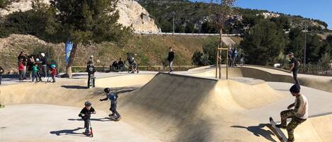 Ein Skatepark mit verschiedenen Rampen und einer Gruppe von Leuten, die Skateboard fahren.