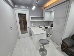 Quarto duplo luxo | Cozinha privada | Geladeira, chaleira elétrica, mesas de jantar