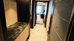A hallway with a marble counter, a bed, and a desk in a hotel room. - W Residence Hotel Centum City (Busan)