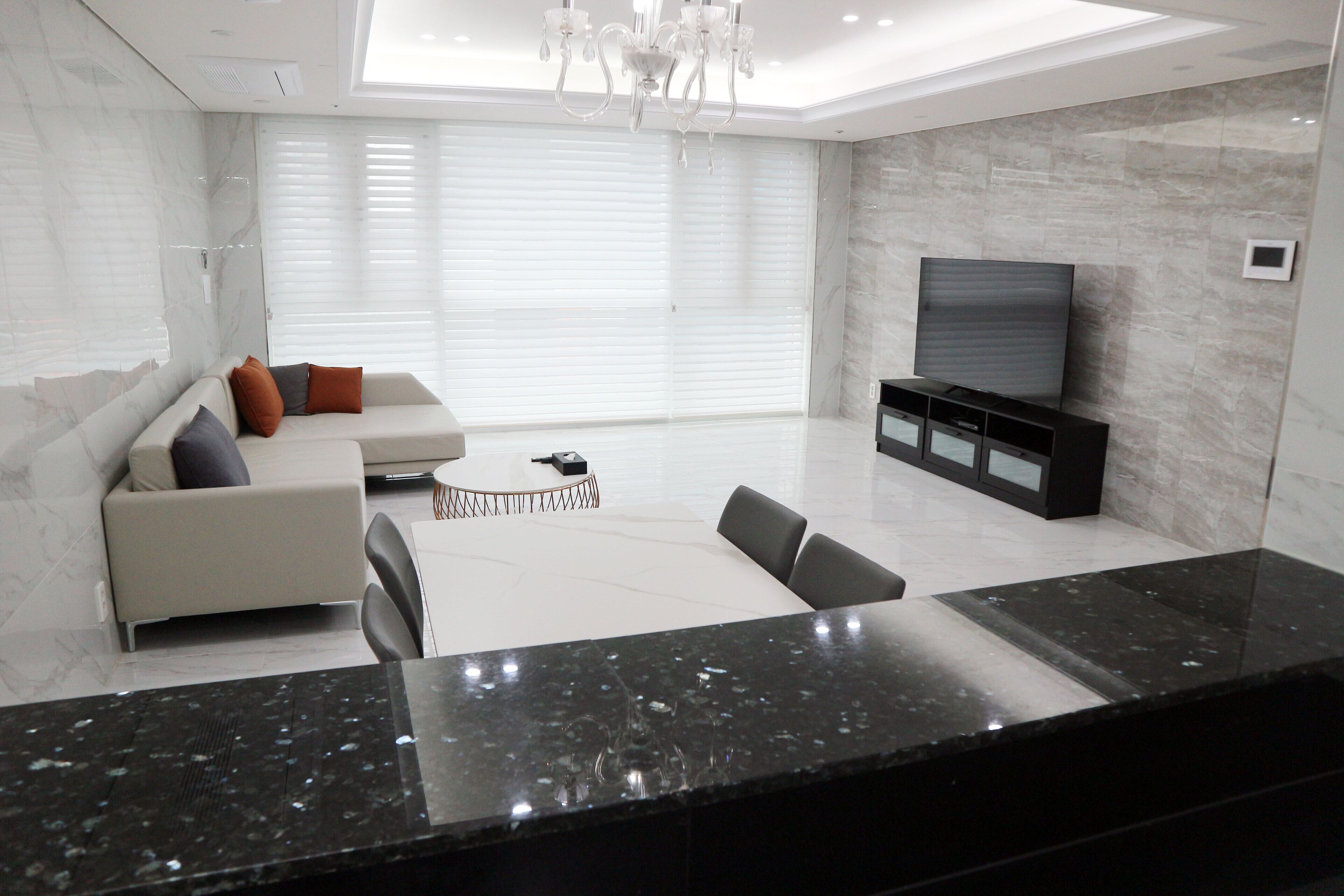 A modern living room with a sofa, a coffee table, and a TV against a wall.